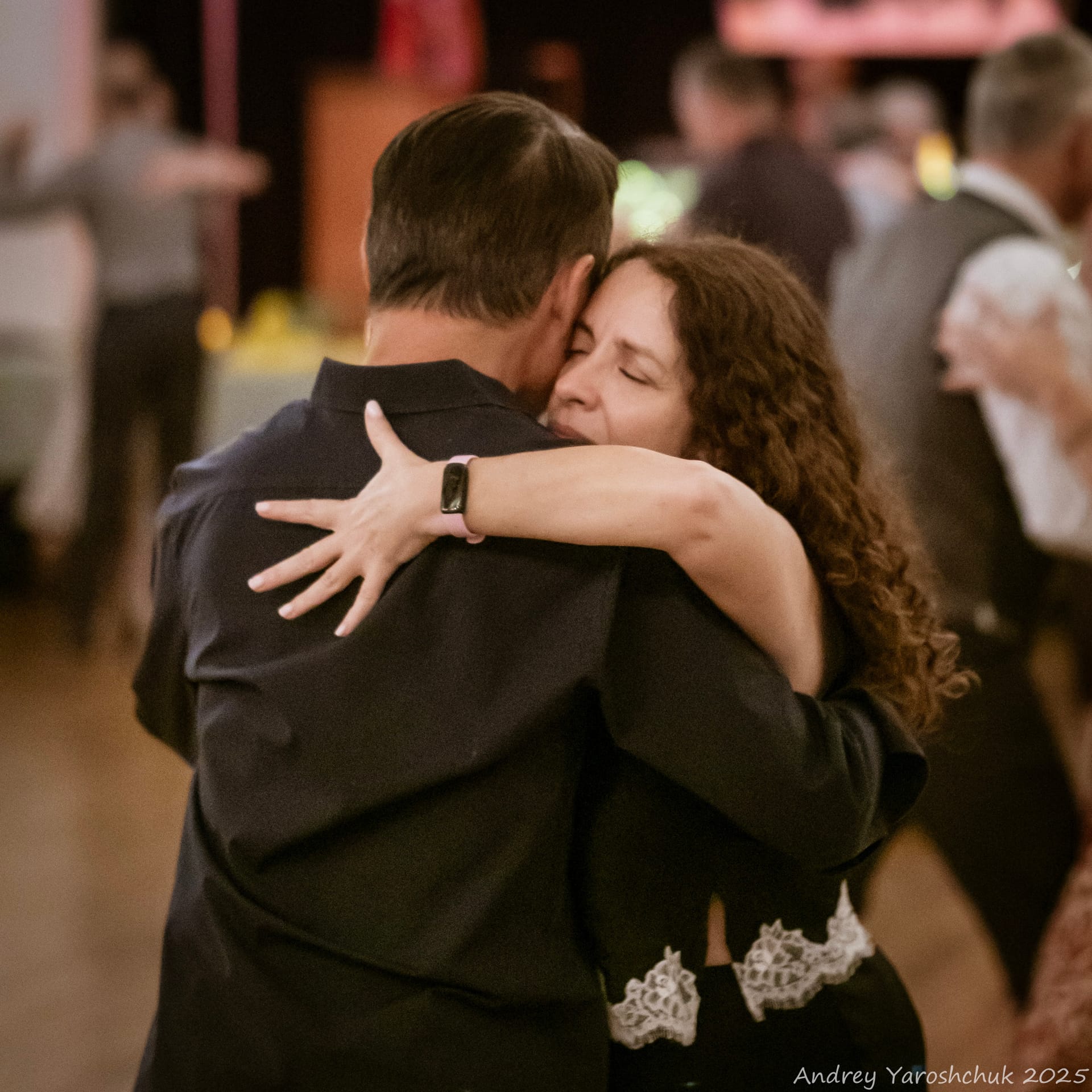 Couple dancing in a close embrace at a milonga